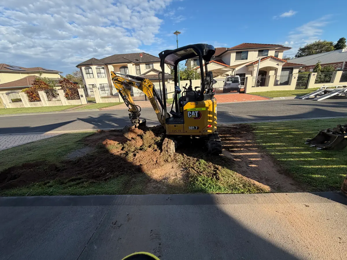 Mini excavator digging out the ground in front of a house before the formwork goes in