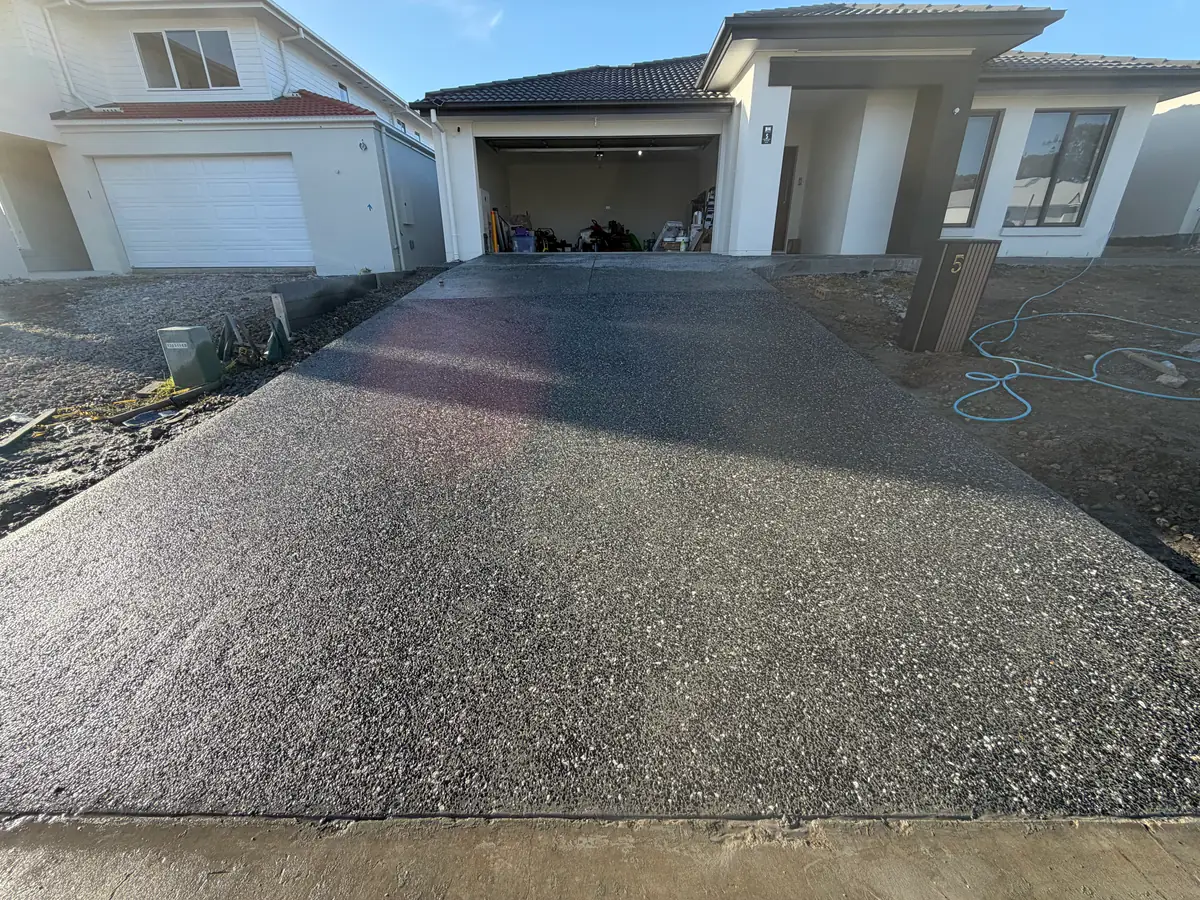 Exposed aggregate driveway leading up to a double garage on a new home