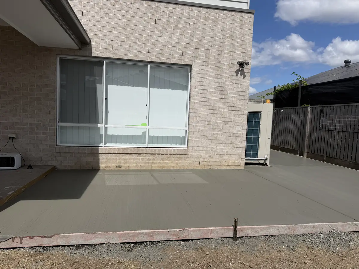 Patio slab poured at the back of a brick home