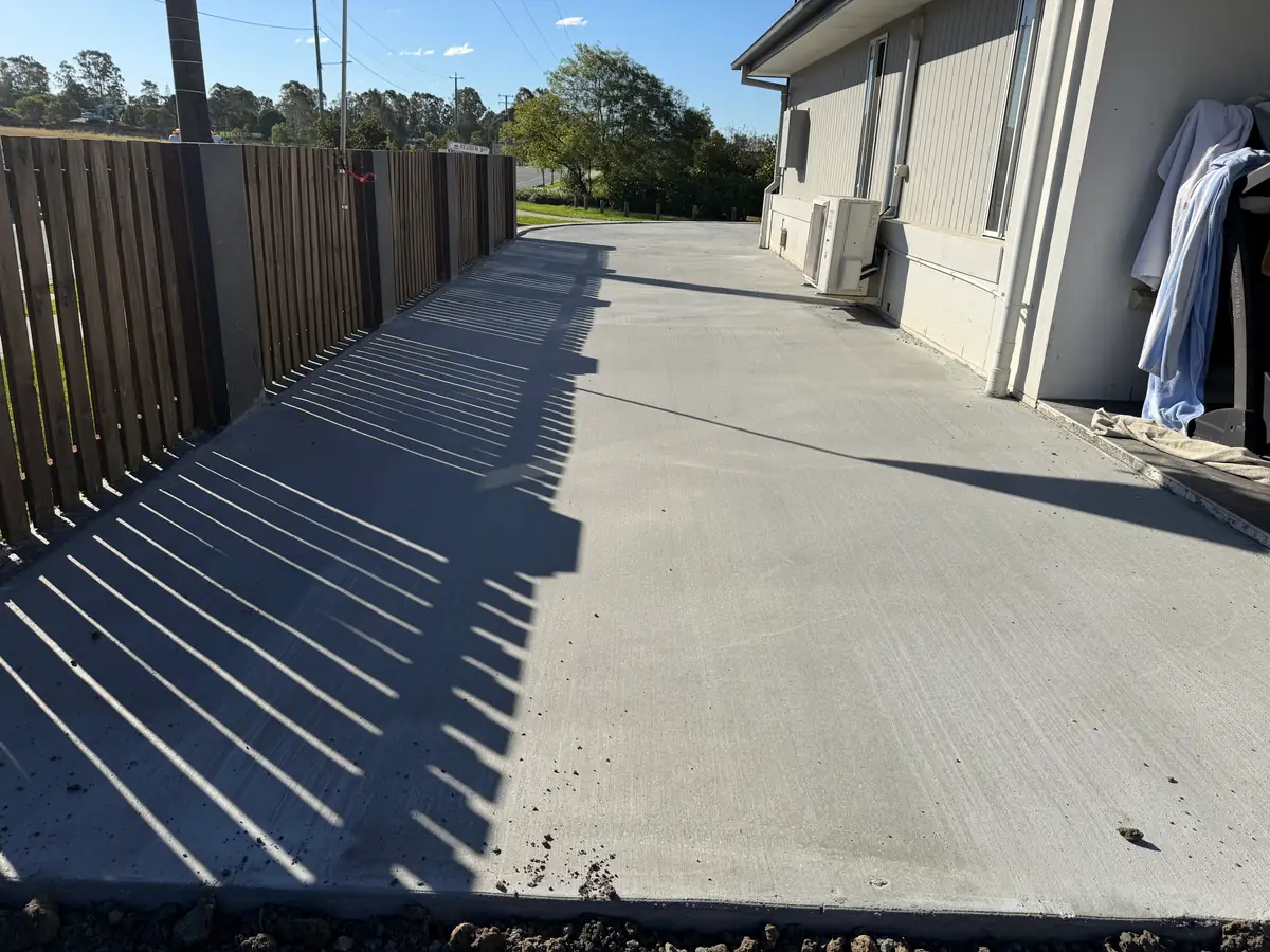 Side path poured between the house and the timber fence
